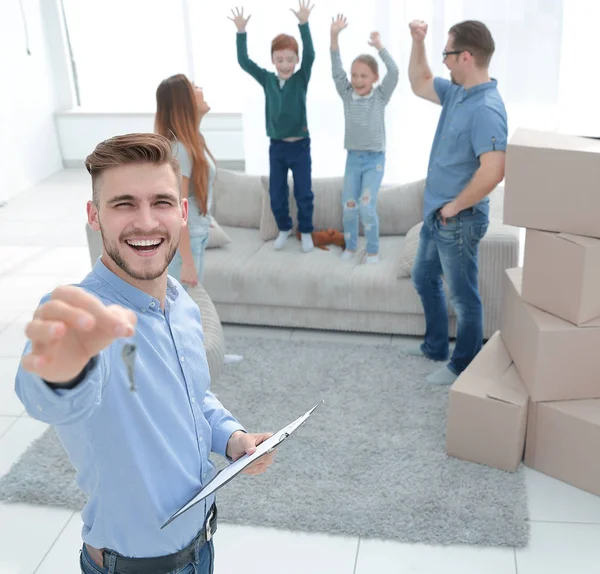 Sorrindo corretor de imóveis com área de transferência mostrando chaves para novo apartamento — Fotografia de Stock