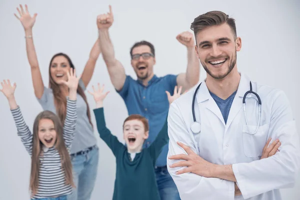 Улыбающийся доктор на фоне счастливой семьи — стоковое фото