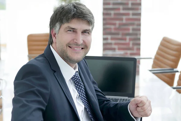 Gerente sorrindo sentado na mesa de trabalho na sala de reuniões . — Fotografia de Stock