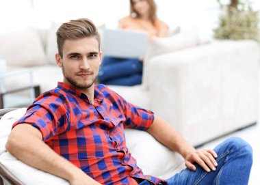 büyük sandalyede oturan genç adam