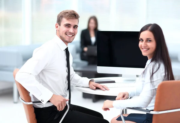 Miembros del equipo de negocios sentados en el escritorio y mirando a la cámara  . —  Fotos de Stock