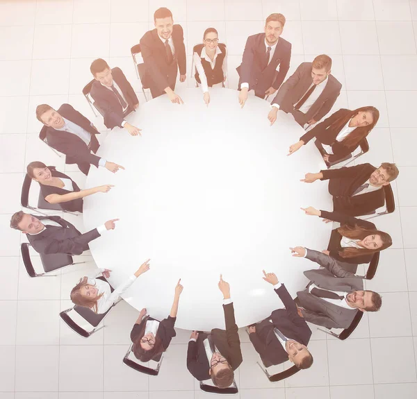 Equipo de negocios indica el centro de la mesa redonda . — Foto de Stock