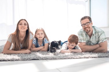 Mutlu aile Halı yeni evde odada yatan