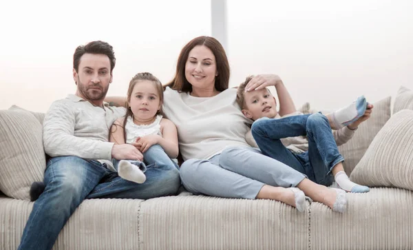 Rodina sedí na gauči v volný večer. — Stock fotografie