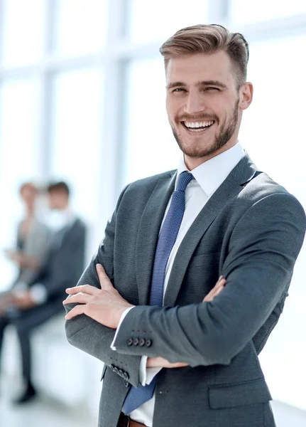 Succesvolle zakenman op de achtergrond van een heldere kantoor. — Stockfoto