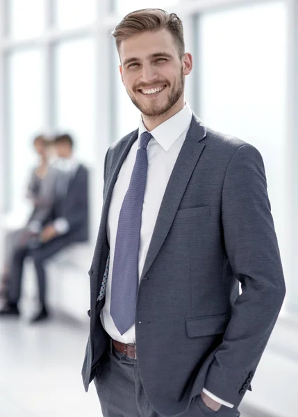 Uśmiechający się biznesmen stojąc w nowoczesnym biurze — Zdjęcie stockowe