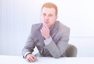 bir masanın arkasında oturan başarılı iş adamı