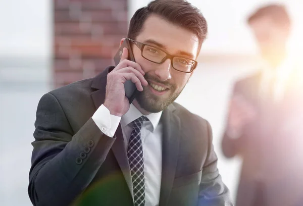 Imagen del joven empresario hablando por teléfono móvil con los clientes — Foto de Stock