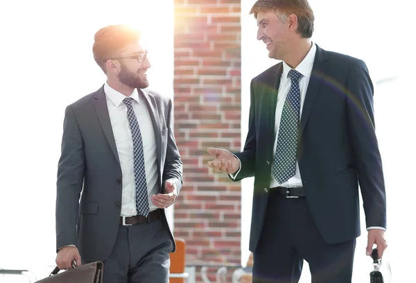 Geschäftspartner gehen in Bürogebäude und reden — Stockfoto