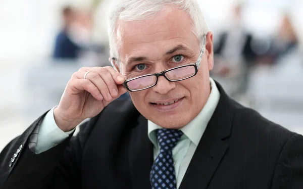 Primer plano de un empresario sénior ajustando sus gafas — Foto de Stock