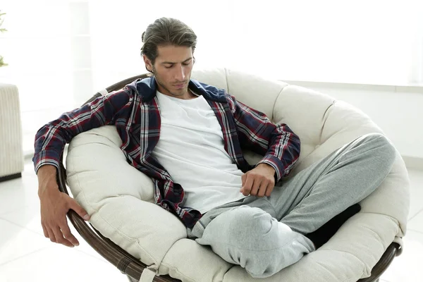 Tipo elegante estiramiento en una silla cómoda —  Fotos de Stock