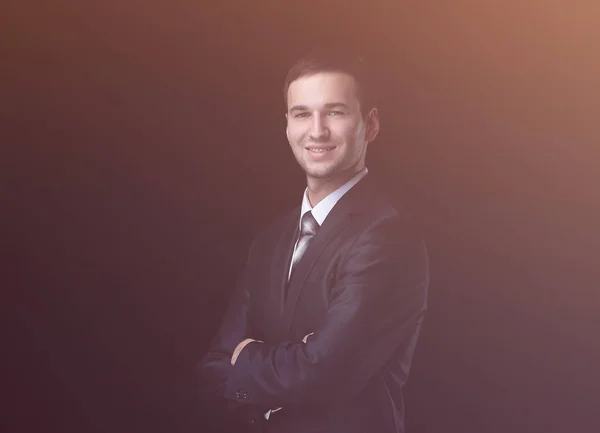 Красивый молодой бизнесмен стоит на черном фоне — стоковое фото