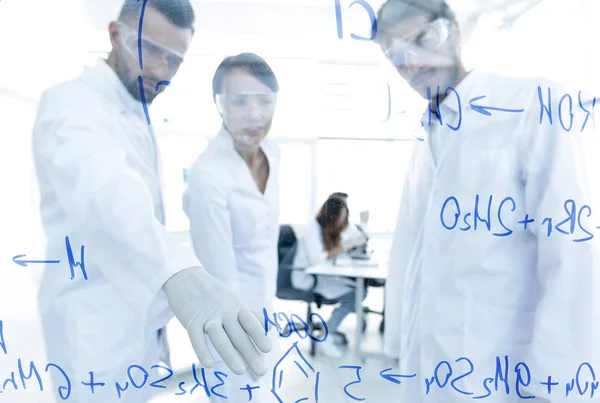 Grupp av unga forskare talar i ett labb — Stockfoto