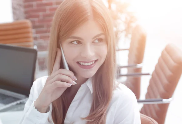 Close seup.female assistant talking on mobile phone in office — стоковое фото