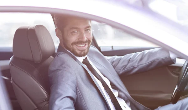 Handsome businessman in the drivers seat in his car — Stock Photo, Image