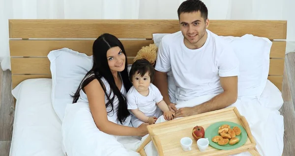 Madre, padre, bebé en la cama en la habitación —  Fotos de Stock