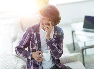 güzel bir fincan adamla bir dizüstü bilgisayar önünde oturur.