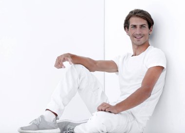 Beyaz bir duvar oturan üzgün genç adam