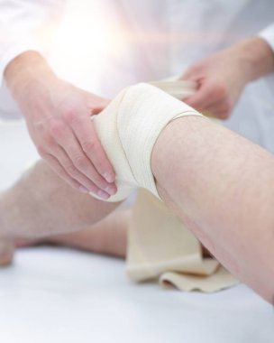 Doktor bir klinik Oda hastalar bacağından yara davranır