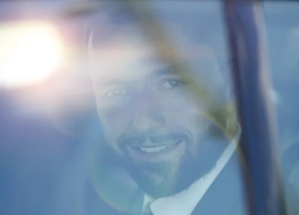 A causa di un bicchiere di uomo d'affari sorridente sul sedile posteriore di una macchina . — Foto Stock