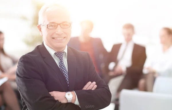 Smiling senior boss in the background of the office — Stock Photo, Image