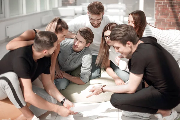 Jóvenes empresarios que debaten documentos comerciales en una reunión informal — Foto de Stock