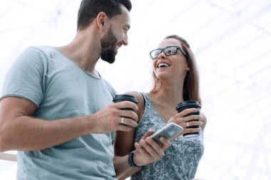 Genç çift kahve içer ve bir akıllı telefon üzerinde sokak o kullanır