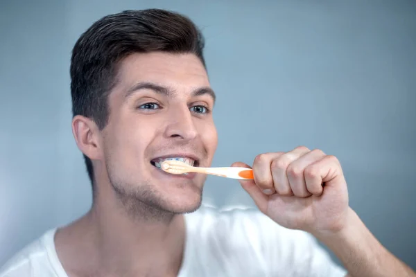 young man brushing his teeth in the bathroom