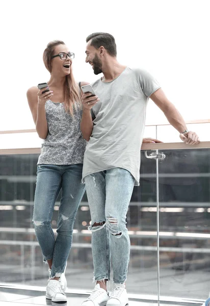 Пара туристов со смартфонами, стоящими в терминале аэропорта — стоковое фото
