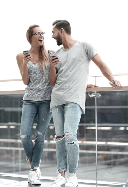 Ein paar Touristen mit Smartphones stehen im Flughafengebäude — Stockfoto