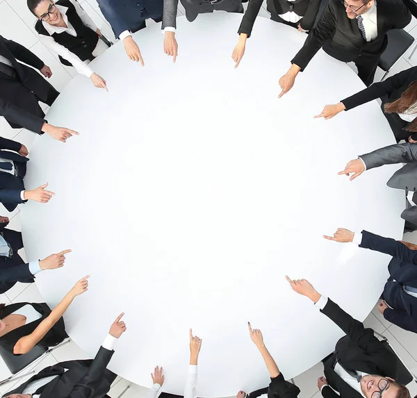 Closeup .business team wijzen in het midden van de tafel. — Stockfoto