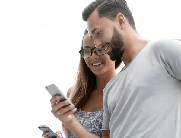 Närbild. Lyckliga unga paret tittar på mobiltelefon. — Stockfoto