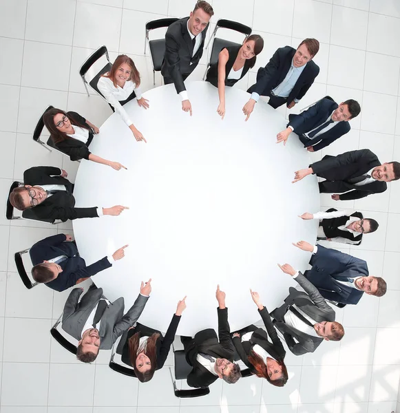 Close up .business team pointing in the center of the table . — стоковое фото