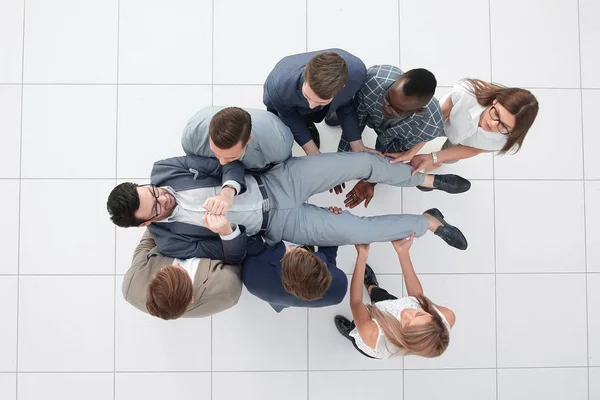 Top view.a divertido equipo de negocios está meciendo a su líder — Foto de Stock