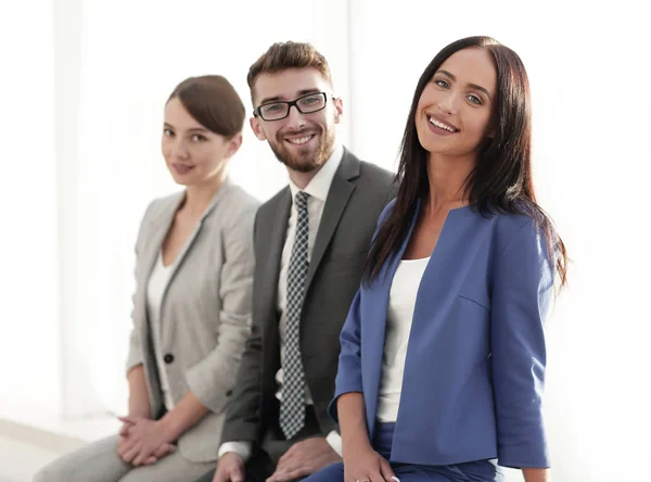 Donna d'affari sorridente con i suoi colleghi sullo sfondo — Foto Stock