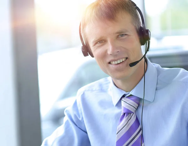 Feliz hombre de negocios en auriculares sonriendo mientras mira a la cámara . — Foto de Stock