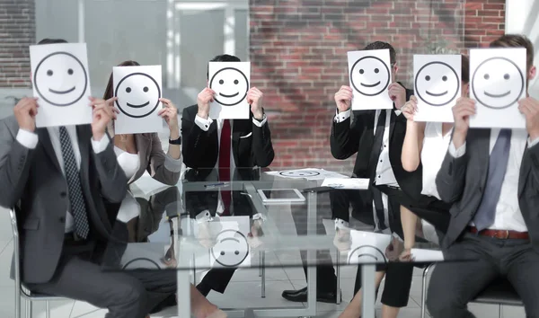 Business team keeps smiley icons sitting at the Desk Stock Image