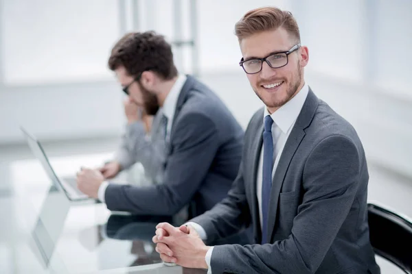 Vue latérale. homme d'affaires souriant sur le fond du lieu de travail — Photo