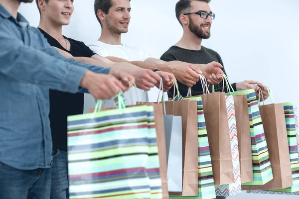Cerrar bolsas de compras en las manos de un grupo de jóvenes —  Fotos de Stock