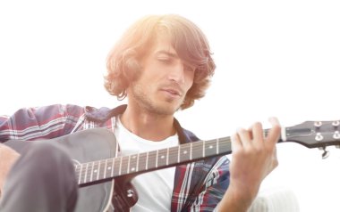 Yakışıklı adam evde kanepede gitar çalmaya