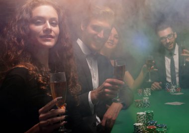 Casino oyun masasında oturan arkadaş grubu