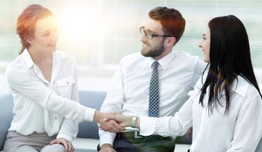 Ofis lobisinde yönetici ve müşterinin el sıkışması.