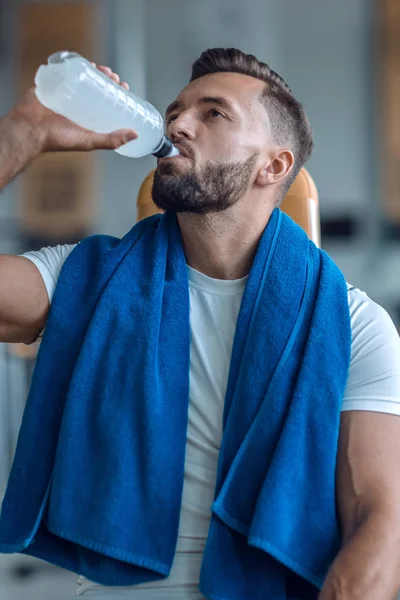 Az edzőteremben palackozott vizet iszik, vonzó férfi — Stock Fotó
