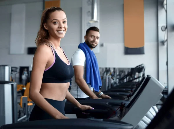 Hermosos deportistas trabajan en la cinta de correr en el gimnasio — Foto de Stock