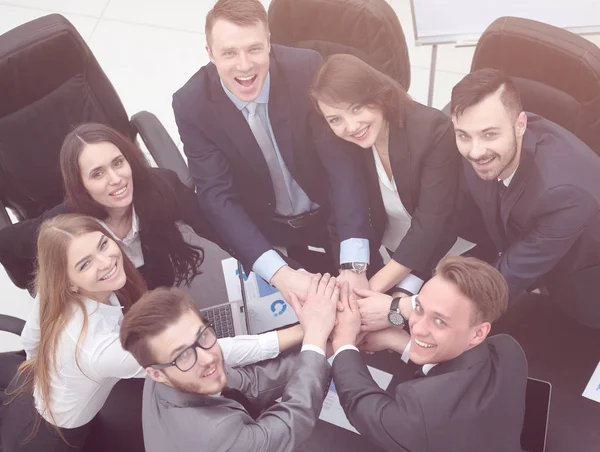 Equipe de negócios com as mãos apertadas juntas na mesa — Fotografia de Stock