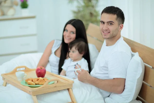 Familia desayunando en la cama en casa —  Fotos de Stock