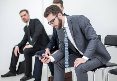 Grup ofis alma içinde oturan bir toplantı için bekleyen iş adamları.