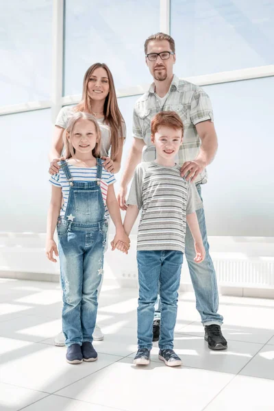 Broer en zus met hun ouders staan in een ruim appartement — Stockfoto