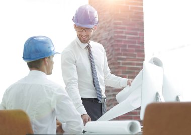 yeni bir projeyi tartışmak üzere mimar ve inşaat ustabaşı