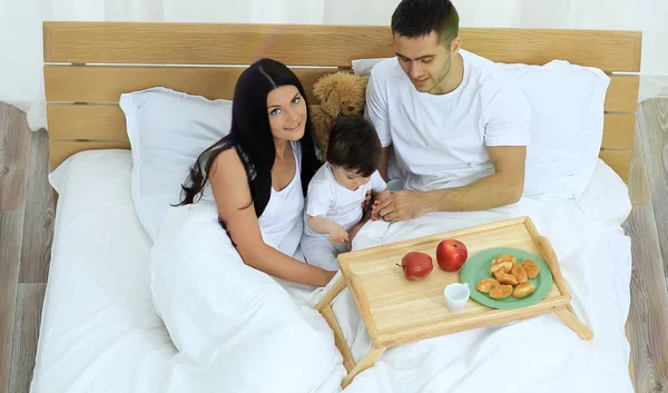 Matka, otec, dítě na lůžku v pokoji — Stock fotografie